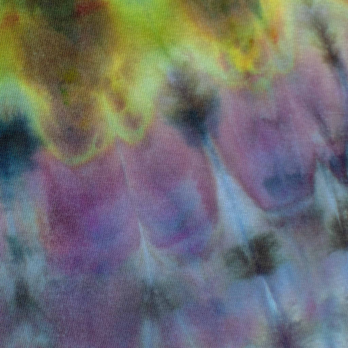 A kaleidoscope of colors forms a spiral ice dye design on this t-shirt, featuring 'Dinkey Creek' in a contrasting print, creating an eye-catching effect