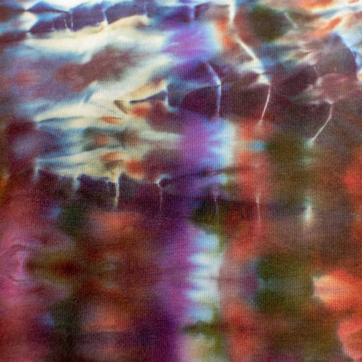 An ice-dyed bandeau top displaying an electric blend of cobalt blue, magenta, and plum, mimicking the natural marbling of semi-precious stones.