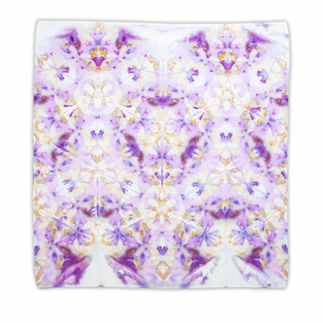 Handcrafted tie-dye bandana with a vibrant display of purple hues and white areas that symmetrically bloom into a pattern reminiscent of flowers and mandalas.