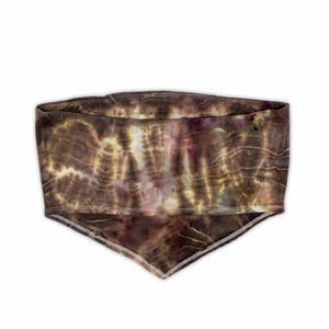 A bohemian-style bandeau top with a moody ice-dyed design, showcasing a blend of deep browns, creams, and specks of pastel hues.